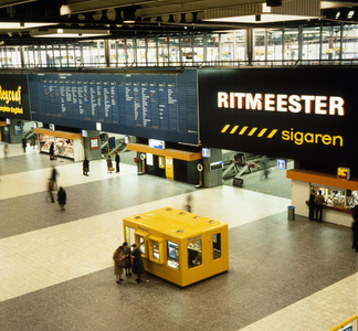 800031 Interieur van het N.S.-station Den Haag C.S. te Den Haag: hal, met centrale treinaanwijzer en informatiestand.
